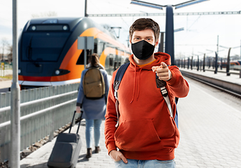 Image showing man in mask with backpack traveling by train