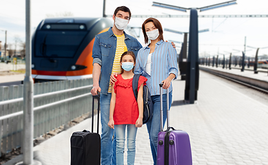 Image showing family in masks with travel bags over train