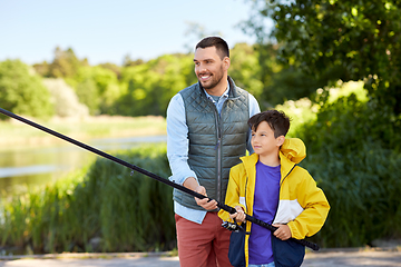 Image showing happy smiling father and son fishing on river