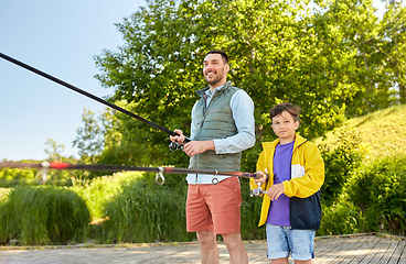 Image showing happy smiling father and son fishing on river