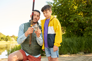 Image showing happy father and son fishing on river