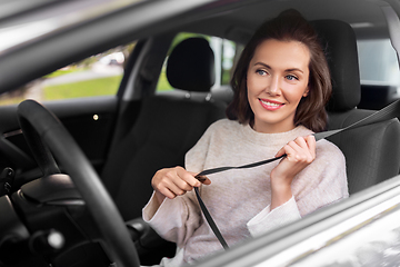 Image showing woman or female car driver fastening seat belt