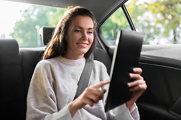 Image showing smiling woman in taxi car using tablet pc computer