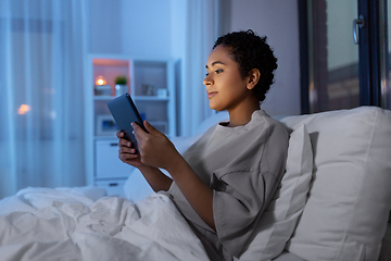 Image showing woman with tablet pc in bed at home at night