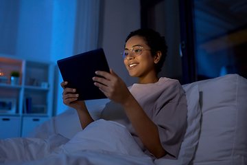 Image showing woman with tablet pc in bed at home at night