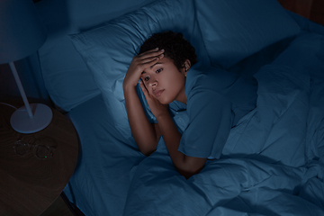 Image showing sleepless african woman lying in bed at night