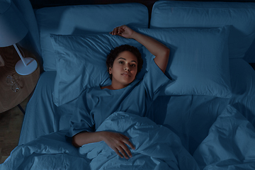 Image showing sleepless african woman lying in bed at night