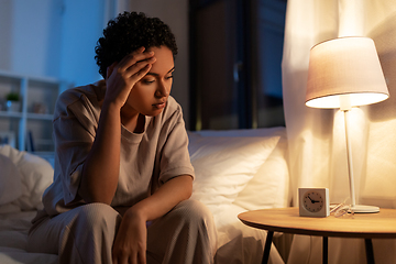 Image showing stressed african woman lying in bed at night