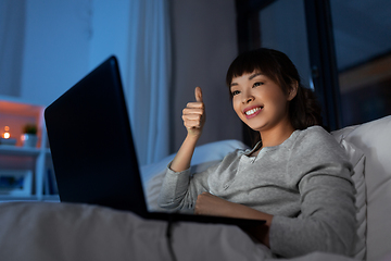 Image showing woman having video call on laptop in bed at night