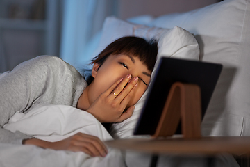 Image showing asian woman with tablet pc in bed at home at night