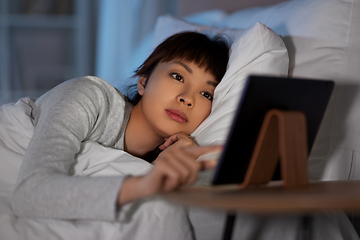 Image showing asian woman with tablet pc in bed at home at night