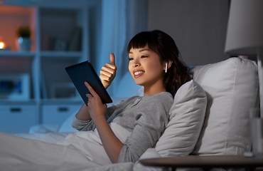 Image showing woman with tablet pc in bed has video call at night