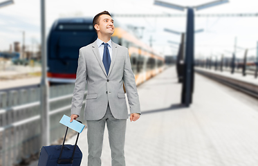 Image showing businessman with travel bag on railway station