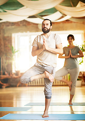 Image showing man and woman doing yoga tree pose at studio