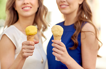 Image showing close up of happy women eating ice cream in city