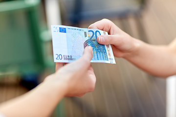 Image showing close up of hands holding euro money