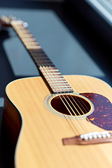 Image showing close up of acoustic guitar on window sill