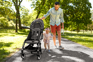 Image showing happy father with child in stroller at summer park