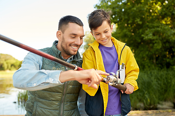 Image showing happy smiling father and son fishing on river