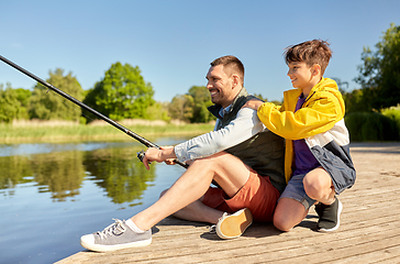 Image showing happy smiling father and son fishing on river