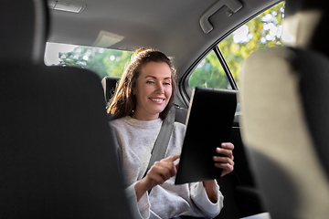 Image showing smiling woman in taxi car using tablet pc computer