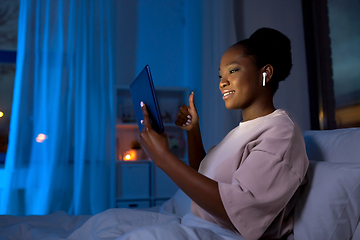 Image showing woman with tablet pc having video call at night