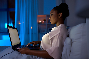 Image showing woman with laptop in bed at home at night