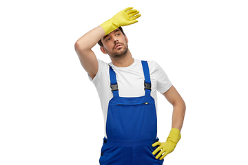 Image showing tired male worker or cleaner in overall and gloves