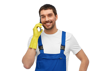 Image showing happy male worker or cleaner calling on smartphone