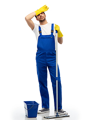 Image showing tired cleaner cleaning floor with mop and bucket