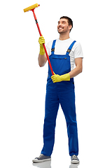 Image showing male cleaner in overall with window cleaning mop