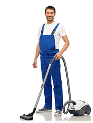 Image showing male worker cleaning floor with vacuum cleaner