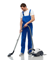 Image showing male worker cleaning floor with vacuum cleaner