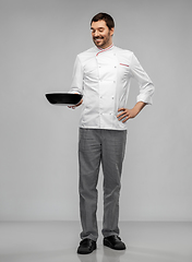 Image showing happy smiling male chef in jacket with frying pan