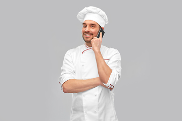 Image showing happy smiling male chef calling on smartphone