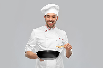 Image showing smiling male chef with frying pan cooking food