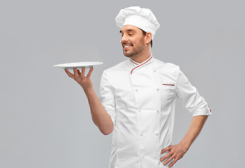 Image showing happy smiling male chef holding empty plate