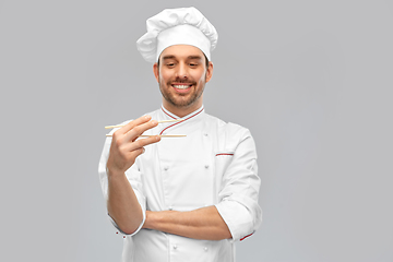 Image showing happy smiling male chef with chopsticks