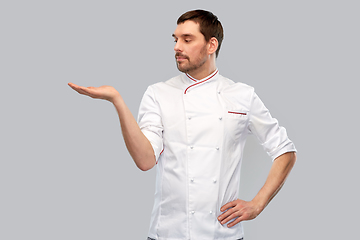 Image showing male chef holding something on hand