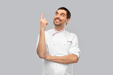 Image showing happy smiling male chef pointing finger up
