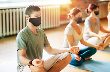 Image showing group of people in masks doing yoga at studio