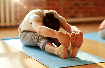 Image showing man doing yoga forward bend at studio or gym