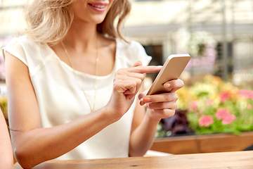 Image showing happy woman with smartphone at street cafe