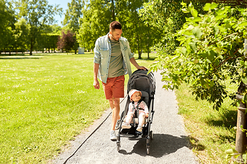 Image showing father with child in stroller at summer park