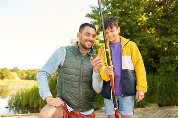 Image showing happy smiling father and son fishing on river