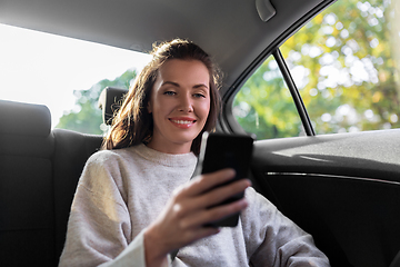 Image showing smiling woman using smartphone in taxi car