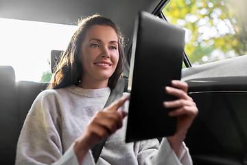 Image showing smiling woman in taxi car using tablet pc computer
