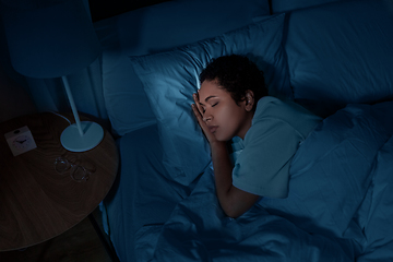 Image showing african woman sleeping in bed at home at night