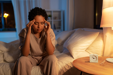 Image showing stressed african woman lying in bed at night