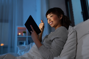 Image showing woman with tablet pc in bed has video call at night